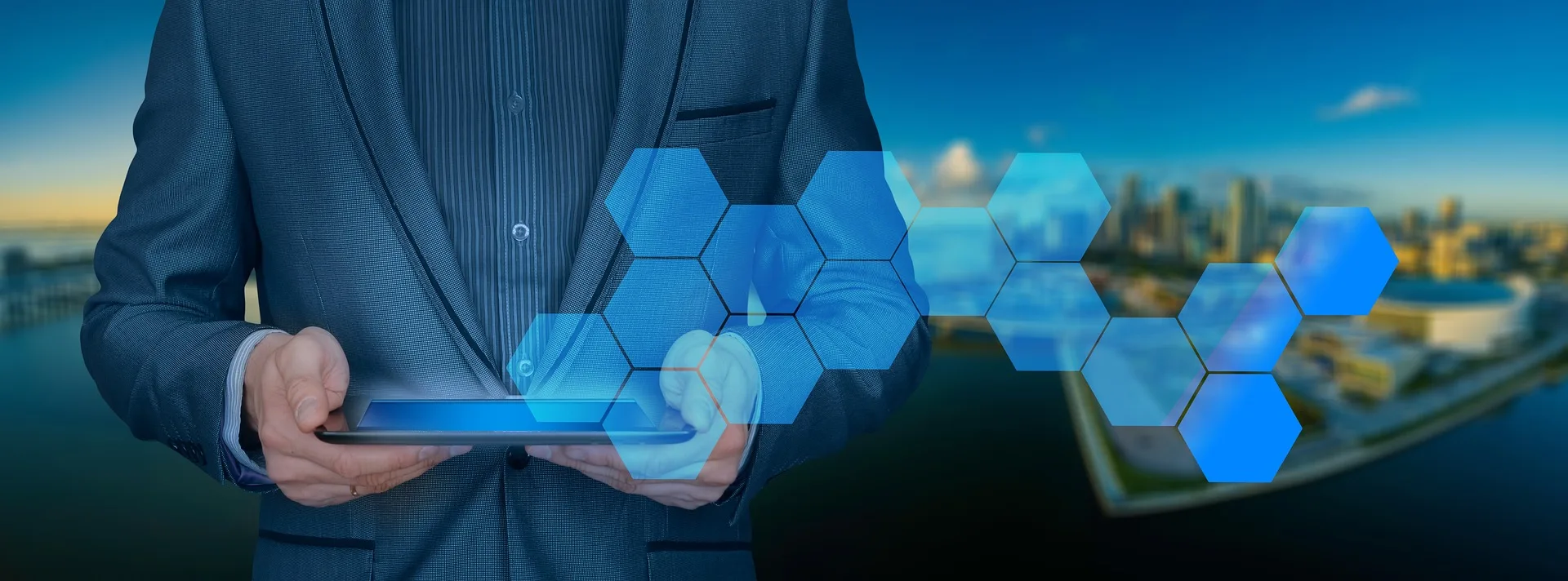 Asset Equalizers banner:
A person in a suit stands holding a tablet flat so we can see part of the screen. The screen is lit up blue and their are holographic blue hexagons across the image as if coming from the screen and to the side. The background is a city scape along a waterfront.